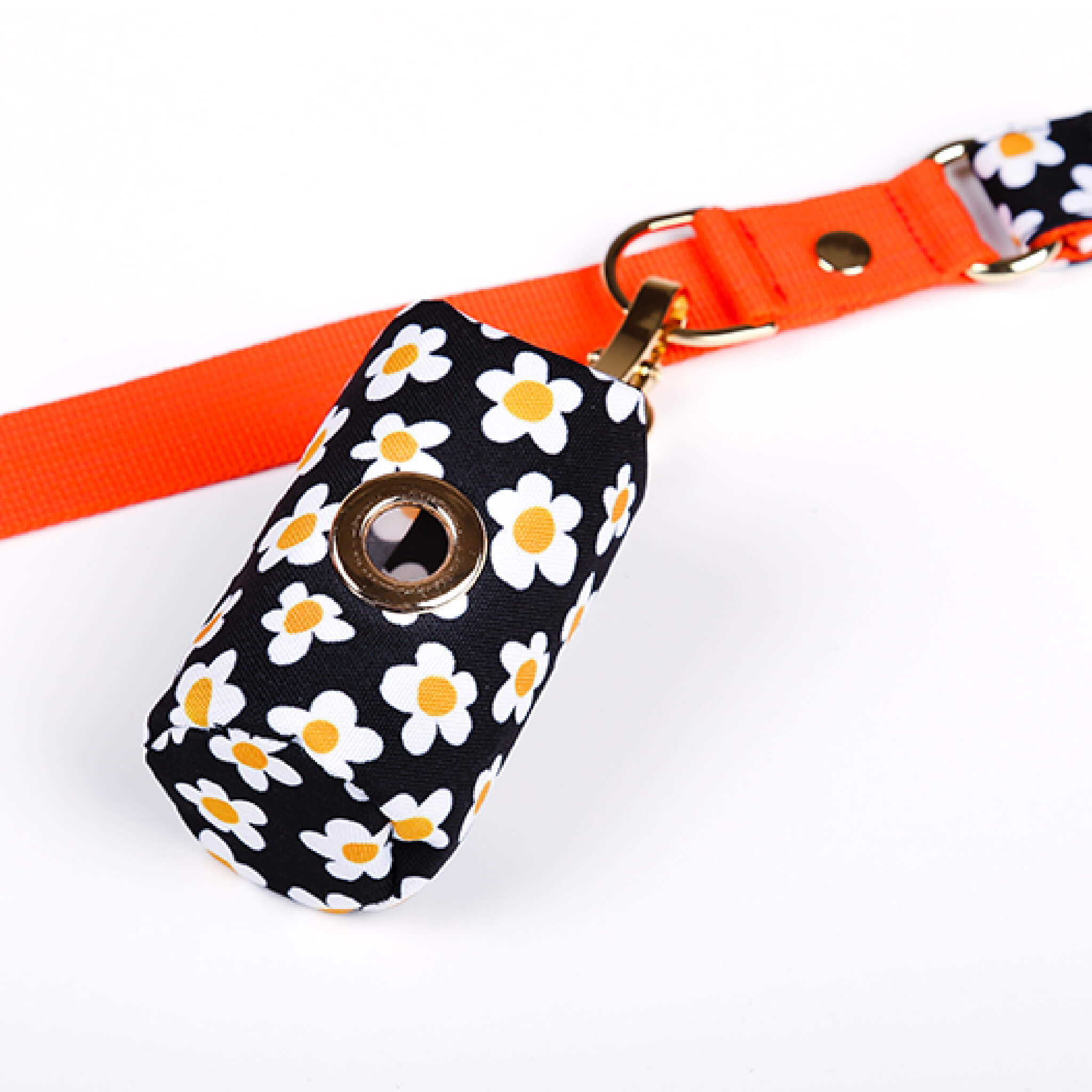 Poop bag holder with a daisy pattern attached to a leash.