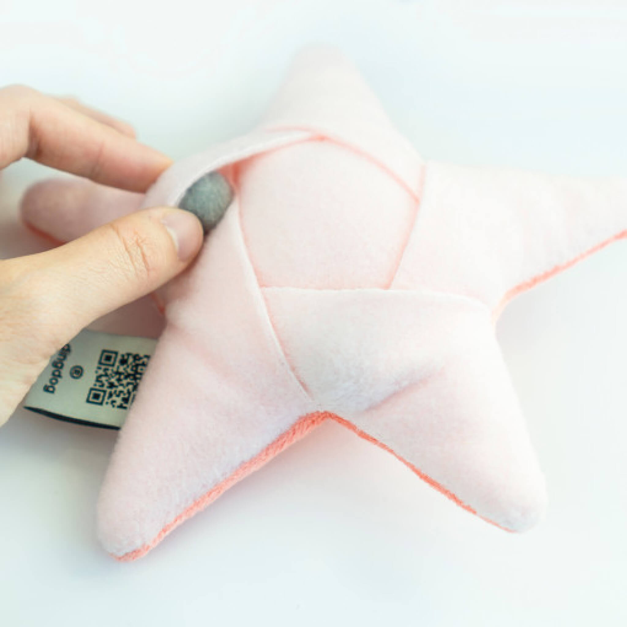 Inserting food and snacks into pockets of starfish nosework toy.